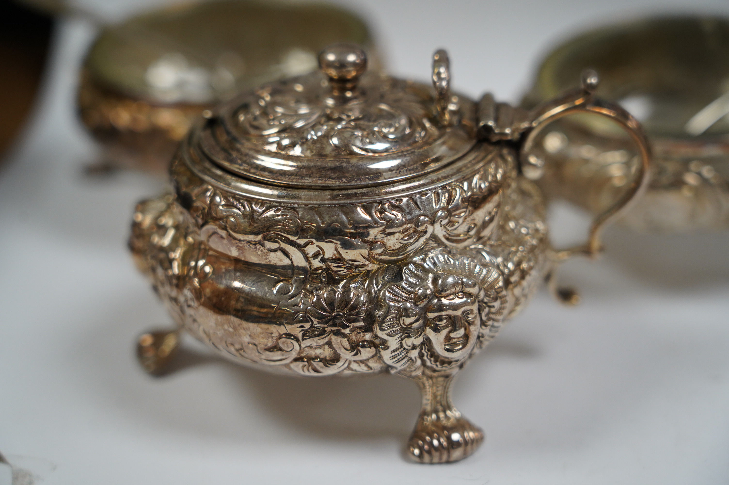 A Georgian Scottish silver mustard pot, width 9cm, marks rubbed, and a pair of similar Irish? silver cauldron salts and two associated later spoons. Condition - poor to fair